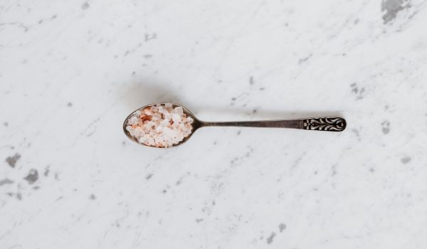 A Spoonful of Himalayan Pink Salt on a Marble Surface