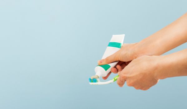 Woman squeezing toothpaste on brush