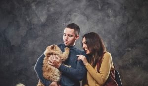 A happy couple is cherishing a moment with their brown cat held by the boy