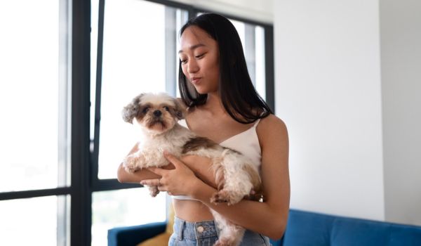 A teenage girl holding a dog