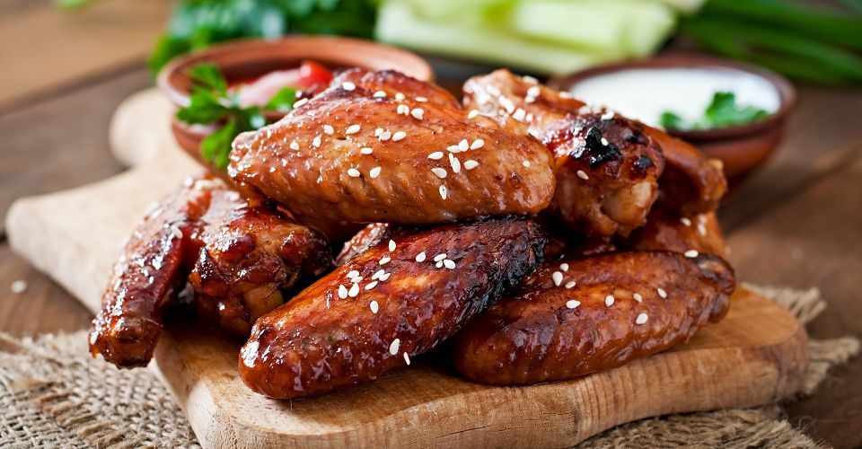 Baked duck wings with teriyaki sauce on a wooden table